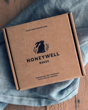 Honeywell Bakes Hug in a Biscuit - Kraft brown gift box with Honeywell Bakes branding on a wooden surface
