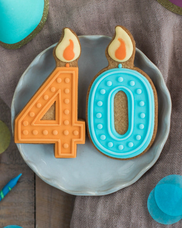 Honeywell Bakes 40th Birthday Biscuits - Two cookies shaped like the number '40' with candle decorations on a gray plate.