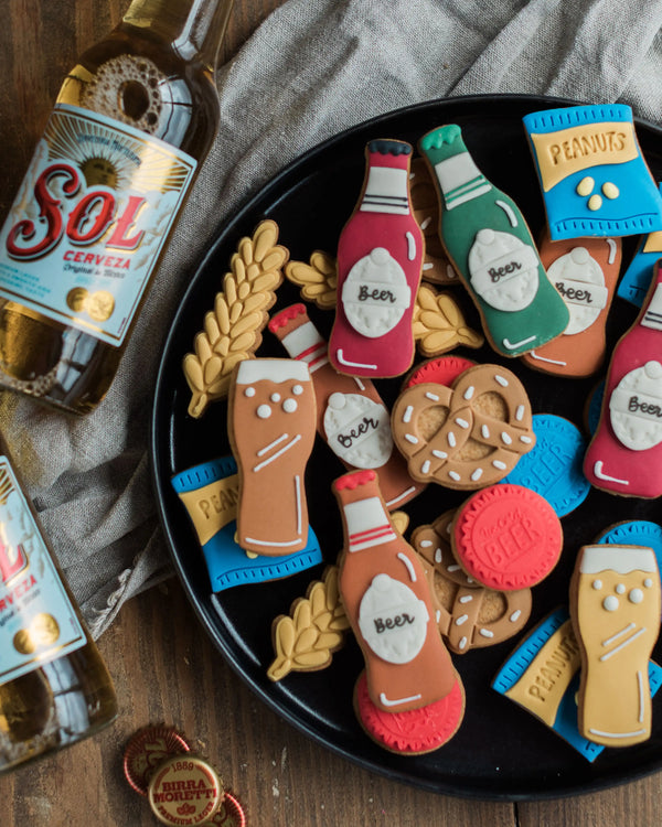 Honeywell Bakes Beer Lover’s Biscuit Jar - Assorted beer-themed cookies on a black plate with Sol beer bottle in the background.