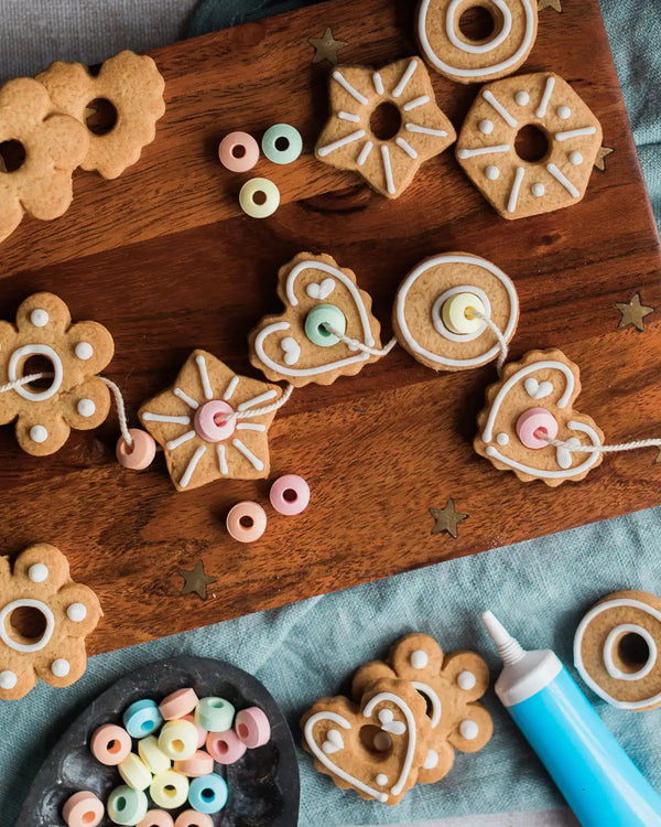 Honeywell Bakes Biscuit Jewellery Craft Kit - Decorative cookies on a wooden board with colourful sweets on a string.