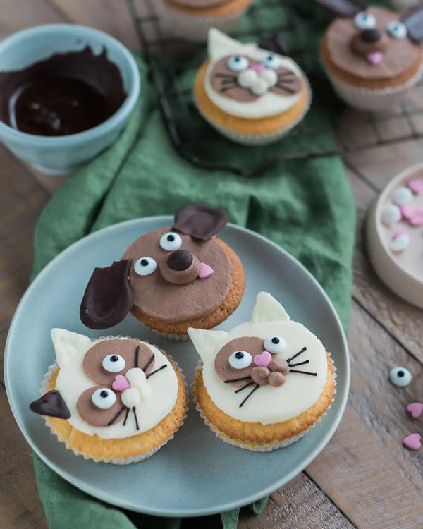 Honeywell Bakes Cat & Dog Cupcake Baking Kit - Cupcakes decorated like animals on a plate with a wooden background