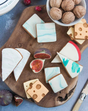 Honeywell Bakes Cheese Biscuit Gift Set - Decorative cookies shaped like cheese and figs on a wooden board with figs and nuts in the background.
