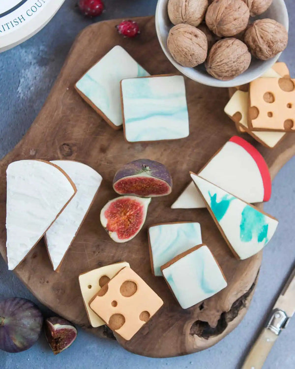 Honeywell Bakes Cheese Biscuit Gift Set - Decorative cookies shaped like cheese and figs on a wooden board with figs and nuts in the background.
