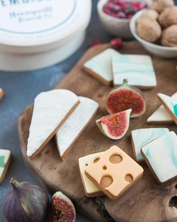 Honeywell Bakes Cheese Biscuit Gift Set - Decorative cookies shaped like cheese and figs on a wooden board with figs and nuts in the background.