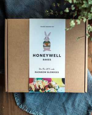 Honeywell Bakes Chocolate Rainbow Blondie Baking Kit packaging with a rabbit illustration on a wooden surface.