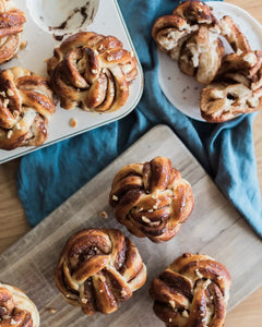 Honeywell Bakes Chocolate & Hazelnut Babka Buns - Baked pastries on a wooden board with a blue cloth underneath