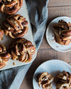 Honeywell Bakes Chocolate & Hazelnut Babka Buns - Baked pastries on a wooden table with a gray cloth.
