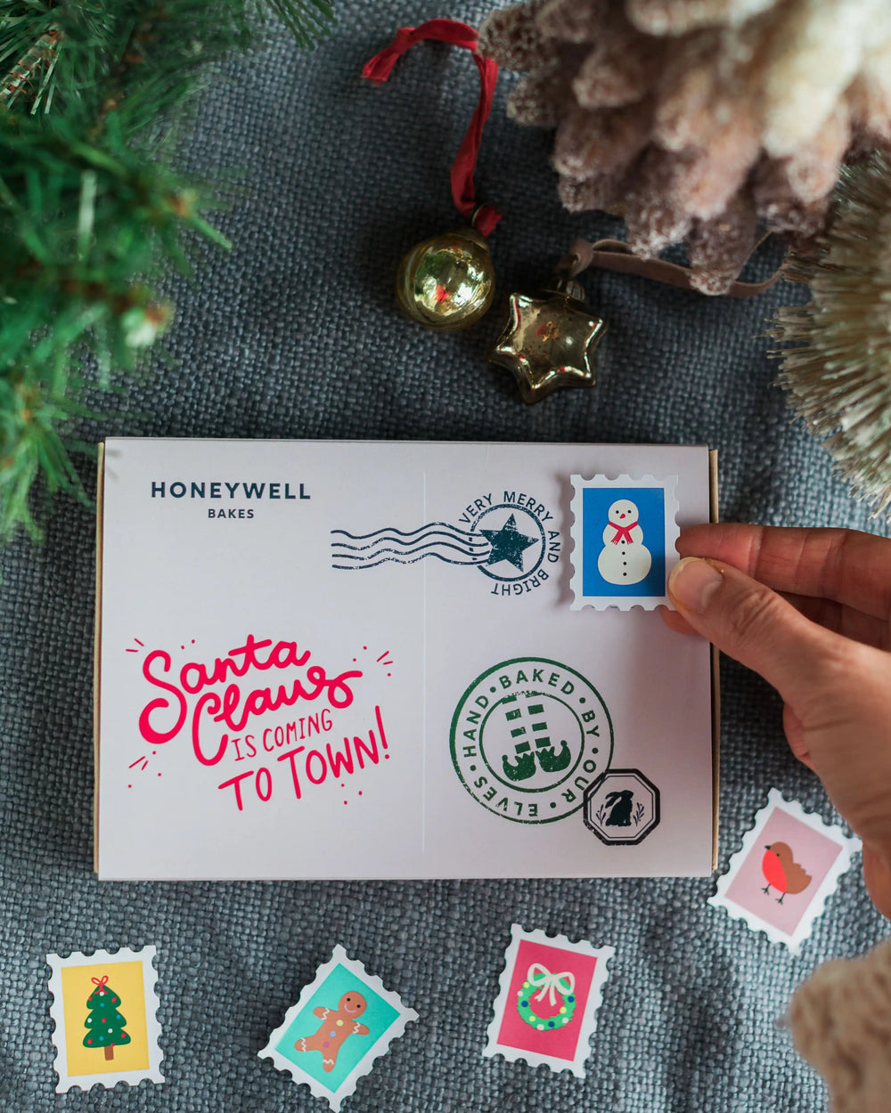 A hand iced Christmas Postcard Biscuit with royal icing piped message in a gift box