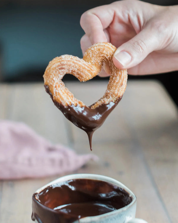 Honeywell Bakes Churros Kit For Baking - Heart-shaped churro being dipped into a cup of chocolate