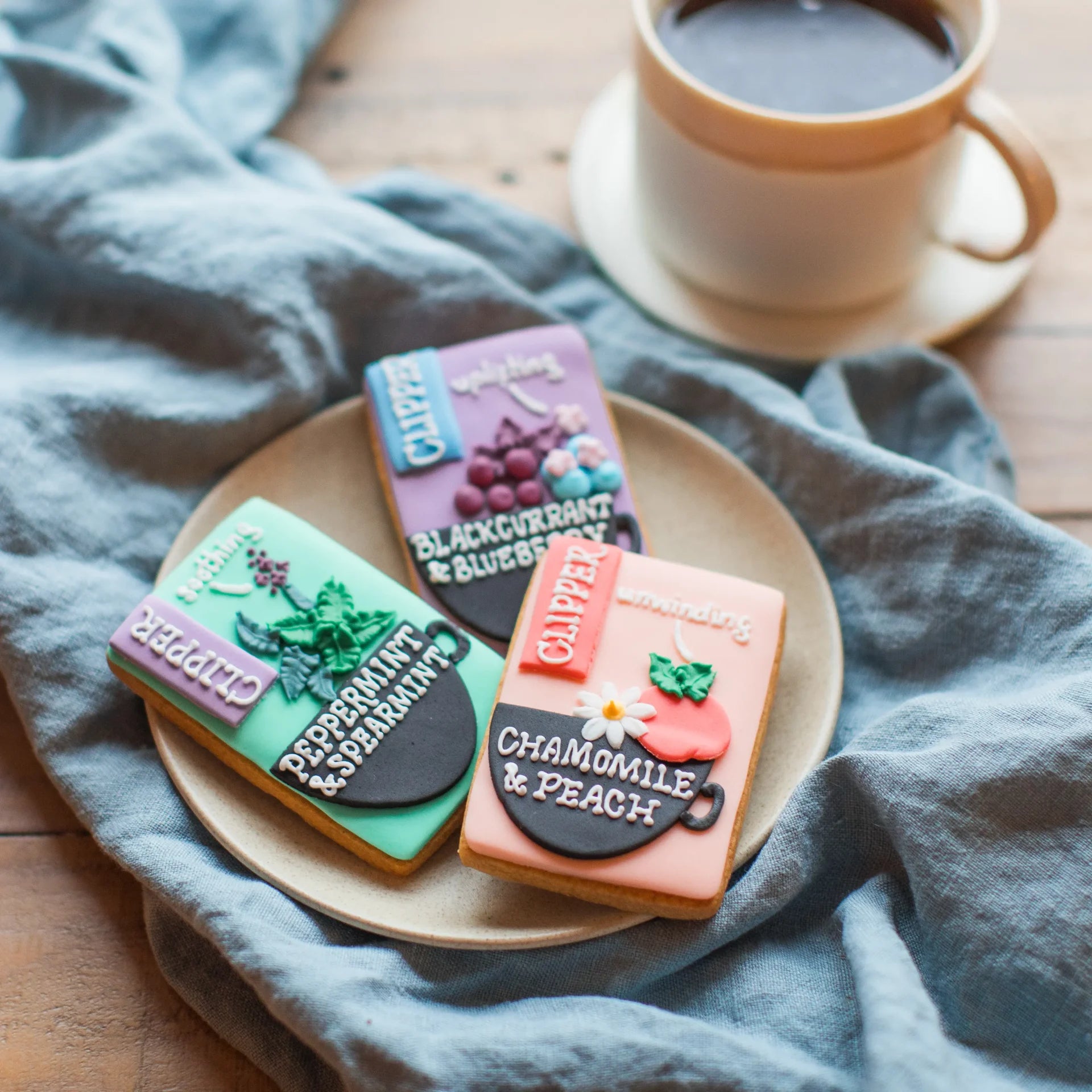 Hand iced branded Clipper Tea biscuits. Cookies decorated to look like Clipper tea packaging by Honeywell Bakes 