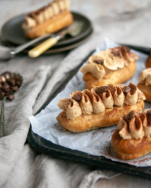 Honeywell Bakes Coffee Eclair Baking Kit - Eclairs with coffee beans on a tray with a grey cloth background