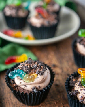 Honeywell Bakes Creepy Crawly Cupcake Baking Kit - Chocolate cupcakes with buttercream frosting and gummy worms on a wooden surface.