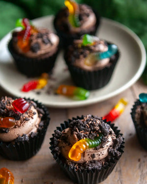 Honeywell Bakes Creepy Crawly Cupcake Baking Kit - Chocolate cupcakes with gummy worms on a plate and surface.