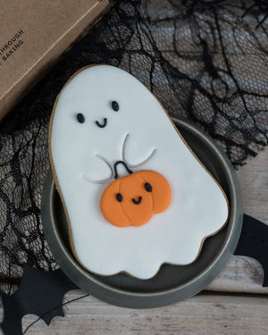 Honeywell Bakes Cute Ghost Biscuit - Ghost-shaped cookie with a pumpkin on a black lace background