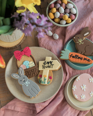 Honeywell Bakes Easter Egg Hunt Biscuit Gift - Easter-themed cookies on a plate with decorative elements on a pink cloth background.