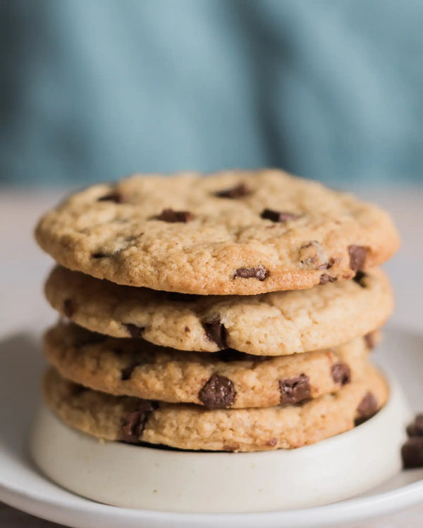 Honeywell Bakes Emergency Tea & Cookies Kit - Stack of chocolate chip cookies on a white plate with a blurred background