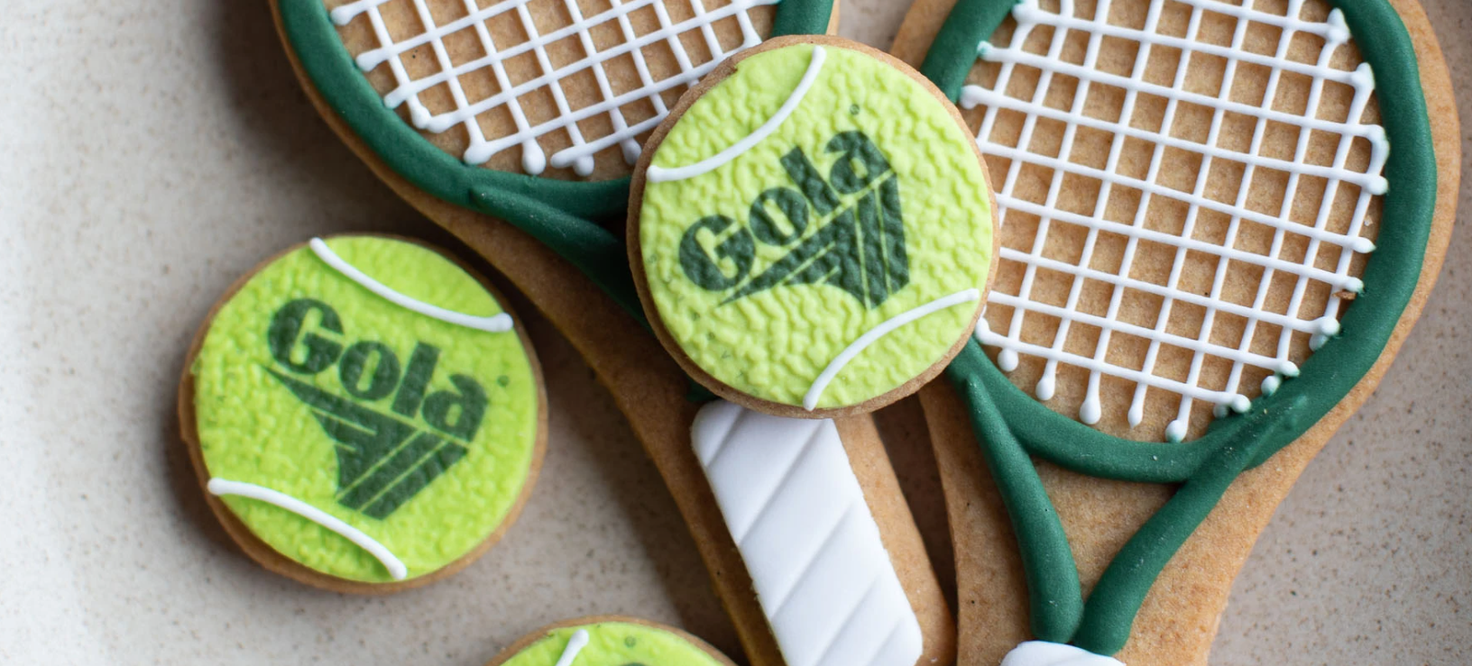 Honeywell Bakes branded cookies shaped like tennis rackets and balls with 'Gola' branding on a light background.
