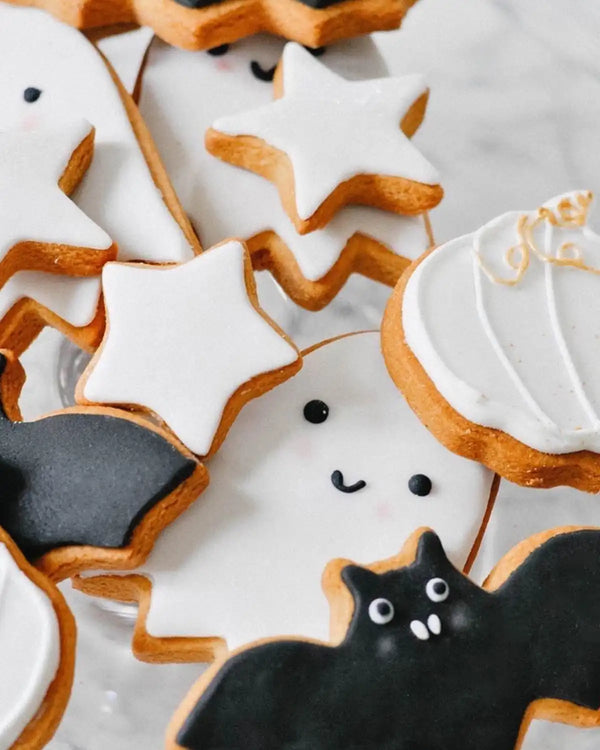 Honeywell Bakes Halloween Biscuit Gift Set - Halloween-themed cookies including ghosts, stars, and a black cat on a white plate.
