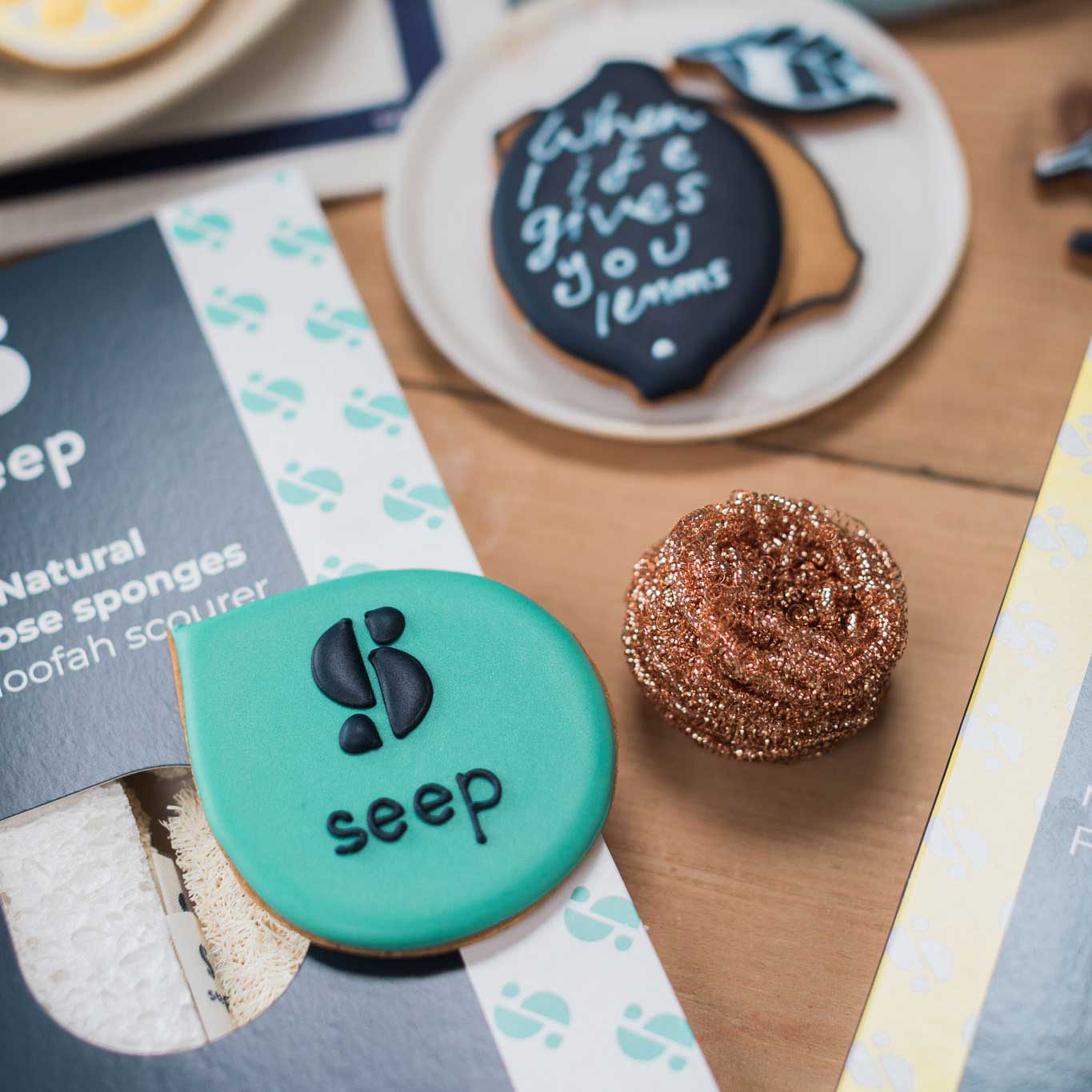 Hand iced custom branded biscuits for cleaning brand Seep, with logo hand piped onto biscuits in their brand shapes and colours