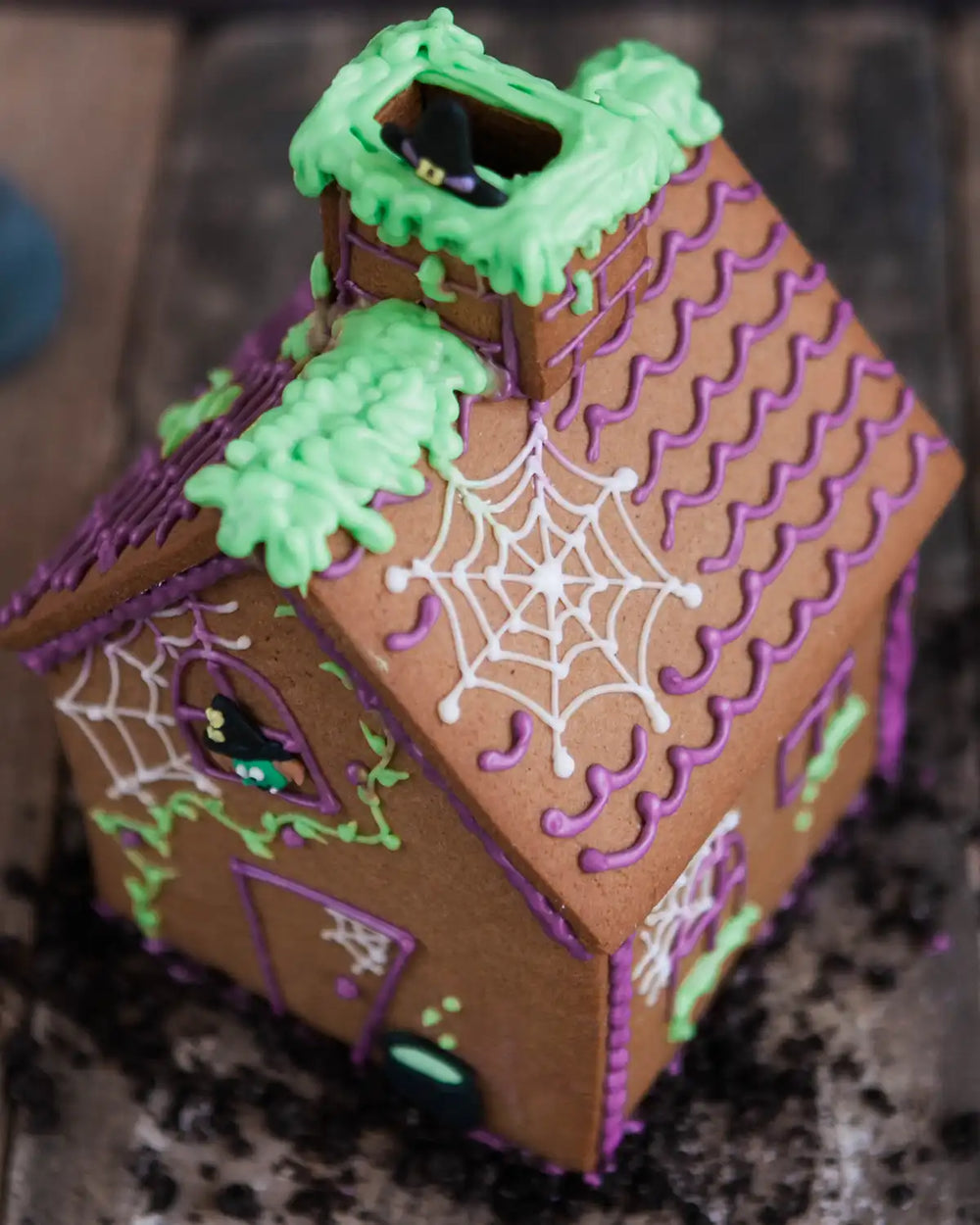 Honeywell Bakes Haunted Gingerbread House Baking Kit - Halloween-themed gingerbread house with purple accents and a witch on a broomstick on top.