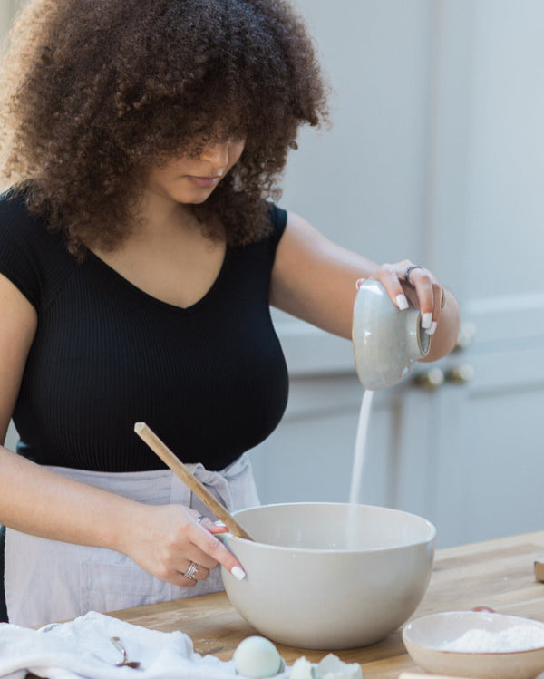Honeywell Bakes Bakers Club Subscription, Woman in a kitchen pouring flour into a bowl