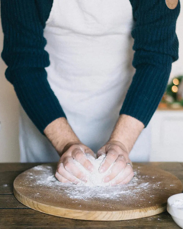 Honeywell Bakes Bread Bakers Subscription, Person kneading dough on a wooden board with flour