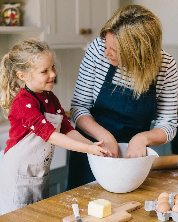 Honeywell Bakes Family Bakers Subscription, Mum and child in aprons mixing ingredients in a kitchen