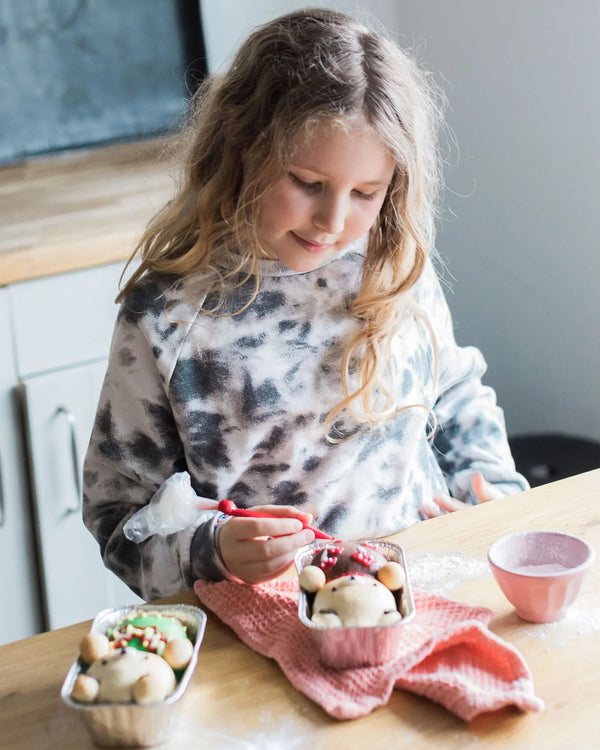 Honeywell Bakes Iced Teddy Bear Loaf Baking Kit - Young girl icing a teddy bun loaf on a kitchen counter