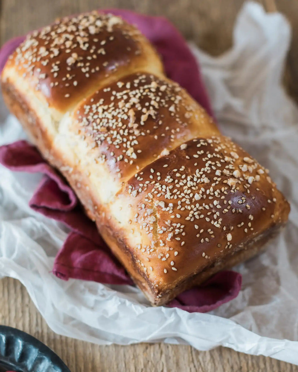 Honeywell Bakes Japanese Milk Bread Baking Kit  - Loaf of bread with sesame seeds and a slice on a purple cloth