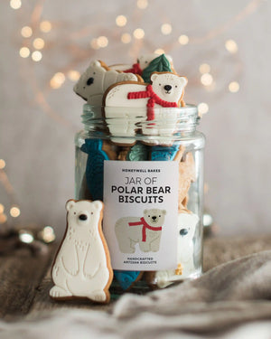 Honeywell Bakes Jar of Polar Bear Biscuits - A glass jar filled with assorted polar bear shaped biscuits, with a single polar bear biscuit standing in front on a rustic surface. The jar label reads 'HONEYWELL BAKES JAR OF POLAR BEAR BISCUITS'.