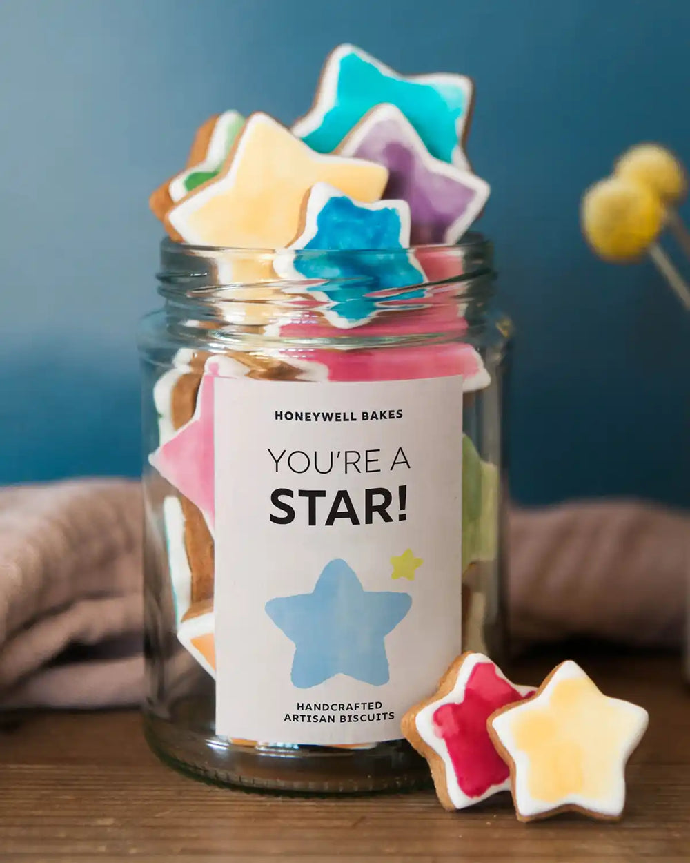 Honeywell Bakes Jar Of You’re A Star Biscuits - Jar of star-shaped cookies with a 'You're a Star!' label on a wooden surface.