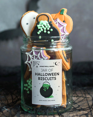Honeywell Bakes Jar of Halloween Biscuits, hand iced halloween shaped biscuits featuring ghosts, pumpkins, spider webs, and cauldrons with a personalised label