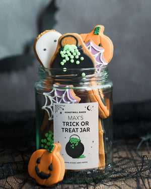 Honeywell Bakes Jar of Halloween Biscuits, hand iced halloween shaped biscuits featuring ghosts, pumpkins, spider webs, and cauldrons with a personalised label