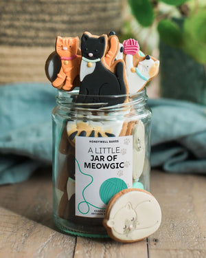 Personalised jars of cat-shaped biscuits, each with a custom label, ideal for unique gifts for cat lovers.