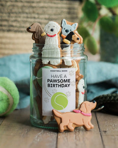 Personalised jar of dog-shaped biscuits from Honeywell Bakes, a cute and thoughtful gift for dog lovers with a custom label.