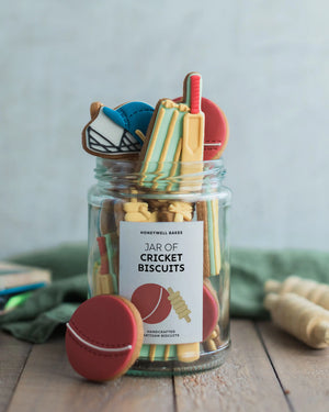 Honeywell Bakes Jar of Cricket Biscuit Gift - Jar of cricket-themed cookies with a decorative label on a wooden surface.