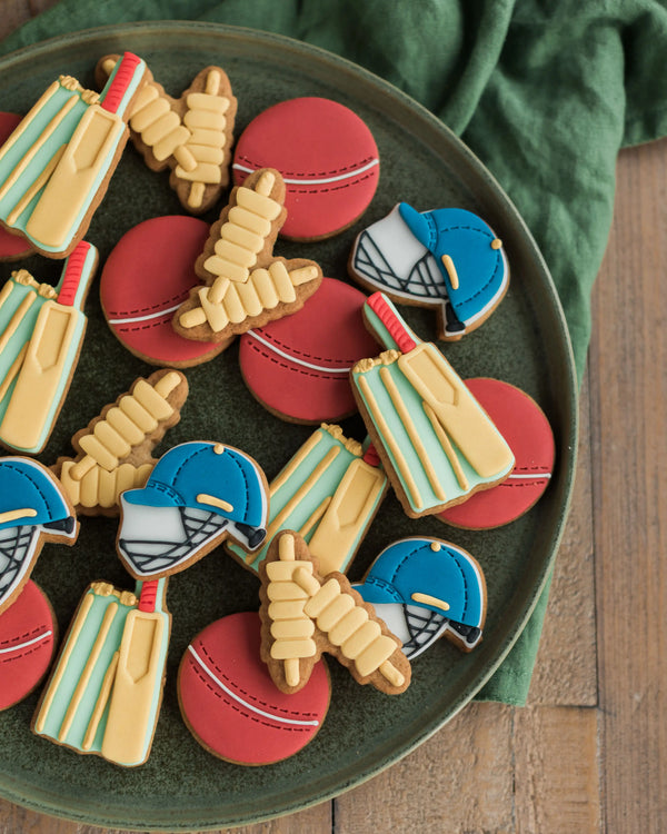 Honeywell Bakes Jar of Cricket Biscuit Gift - Decorative cookies shaped like cricket-themed items on a green plate.