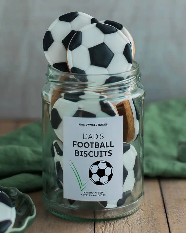Honeywell Bakes Jar of Football Biscuits - Jar of football-shaped cookies with a 'Dad's Football Biscuits' label on a wooden surface.