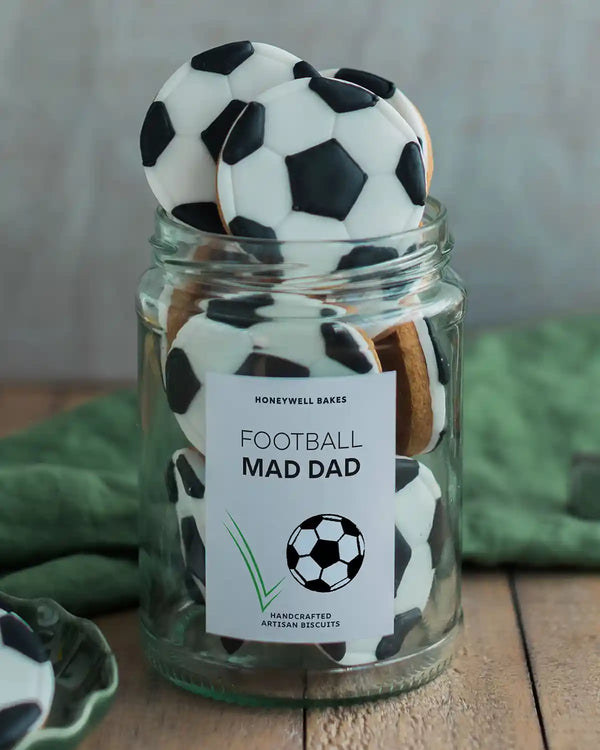 Honeywell Bakes Jar of Football Biscuits - Jar of football-shaped cookies with a 'Football Mad Dad' label on a wooden surface.