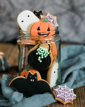 Honeywell Bakes Jar of Halloween Biscuits - Glass jar filled with Halloween-themed cookies on a wooden surface.