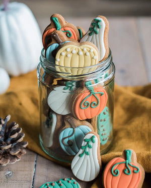 Honeywell Bakes Jar of Pumpkin Biscuits - Decorative cookies shaped like pumpkins and gourds in a glass jar on a wooden surface.