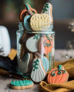 Honeywell Bakes Jar of Pumpkin Biscuits - Decorative cookies shaped like pumpkins and leaves in a glass jar on a wooden surface.