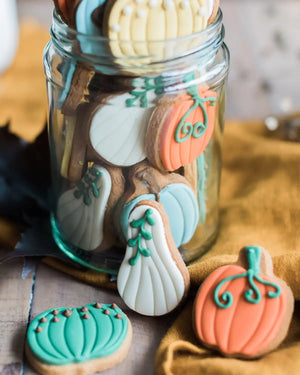 Honeywell Bakes Jar of Pumpkin Biscuits - Decorative cookies shaped like pumpkins and leaves in a glass jar on a wooden surface.