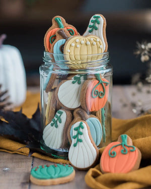 Honeywell Bakes Jar of Pumpkin Biscuits - Decorative cookies shaped like pumpkins and gourds in a glass jar on a wooden surface.