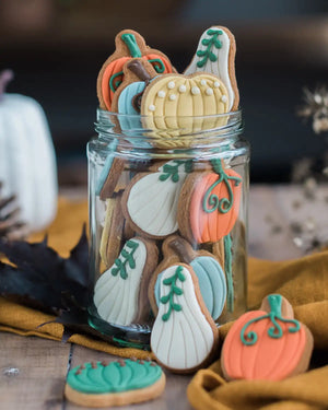 Honeywell Bakes Jar of Pumpkin Biscuits - Decorative cookies shaped like pumpkins and gourds in a glass jar on a wooden surface.