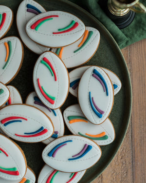 Honeywell Bakes Jar of Rugby Balls Biscuit Gift - Decorative cookies with colourful icing on a green plate