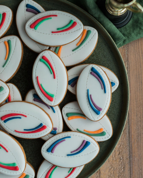 Honeywell Bakes Jar of Rugby Balls Biscuit Gift - Decorative cookies with colourful icing on a green plate