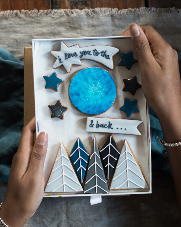 Honeywell Bakes Large I Love You To The Moon And Back Biscuit Gift Set - Handmade biscuit set with decorative elements held by a person
