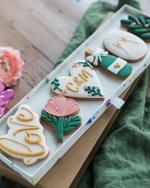 Honeywell Bakes Large Lovely Couple Biscuit Gift Set - Decorative cookies with floral and heart designs on a wooden surface.