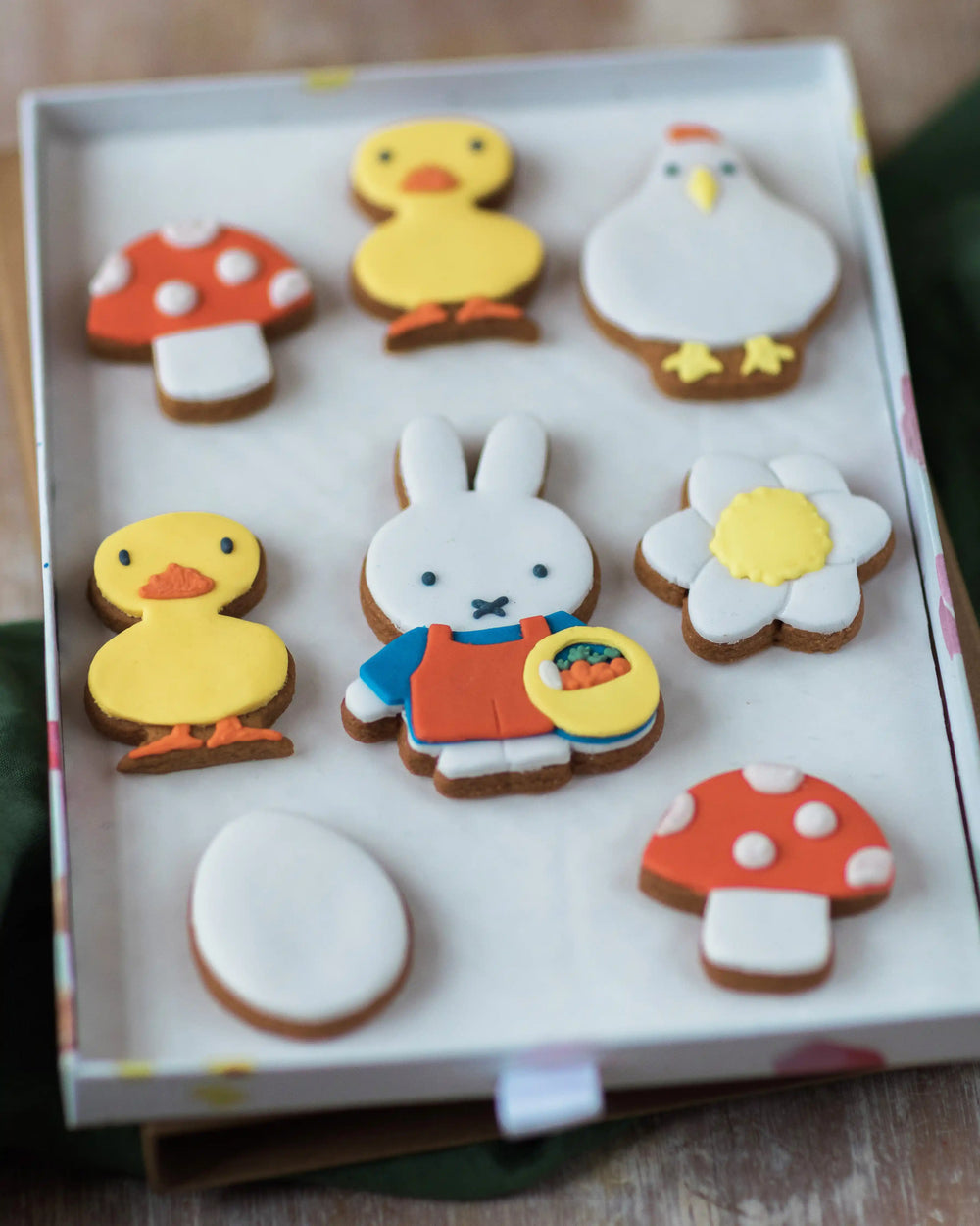 Honeywell Bakes Large Miffy Spring Biscuit Gift Set - Box of decorated cookies shaped like animals and objects on a wooden surface.